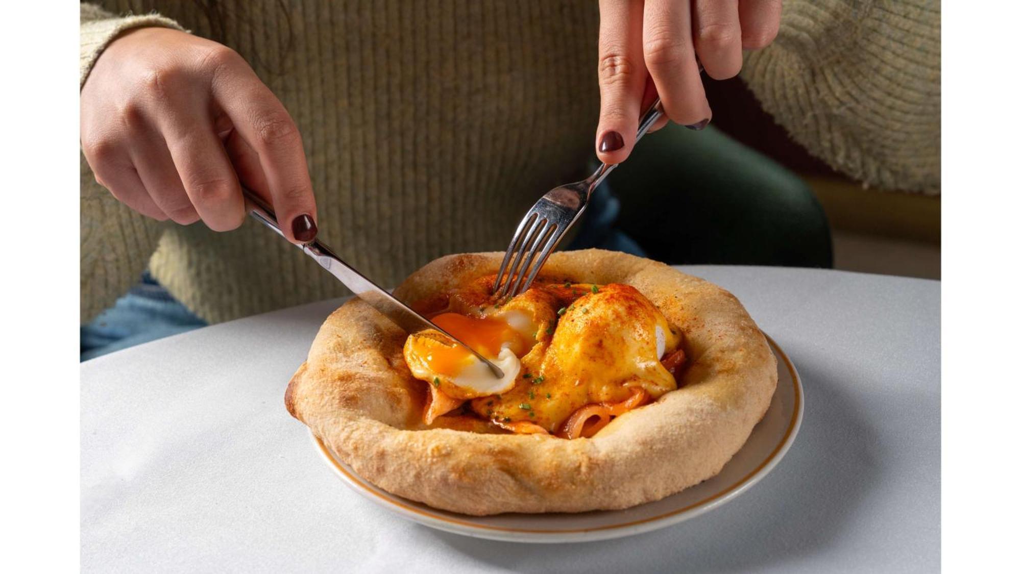 Art'Otel London Battersea Power Station, Powered By Radisson Hotels Esterno foto A person cutting into a pizza